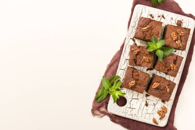 Brownie tatlı çikolata tatlı ceviz ve retro kurulu demek yapraklarda pastel bej renkli arka plan üzerinde kopya alanı ile. Lezzetli kahverengi kakao pişmiş pasta ile güzel afiş.