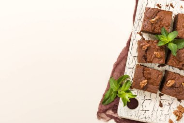 Brownie tatlı çikolata tatlı ceviz ve retro kurulu demek yapraklarda pastel bej renkli arka plan üzerinde kopya alanı ile. Lezzetli kahverengi kakao pişmiş pasta ile güzel afiş.