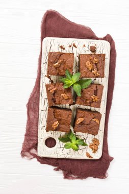 Brownie tatlı çikolata tatlı ceviz ve retro kurulu demek yapraklarda pastel bej renkli arka plan üzerinde kopya alanı ile. Lezzetli kahverengi kakao pişmiş pasta ile güzel afiş.