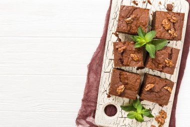 Brownie tatlı çikolata tatlı ceviz ve retro kurulu demek yapraklarda pastel bej renkli arka plan üzerinde kopya alanı ile. Lezzetli kahverengi kakao pişmiş pasta ile güzel afiş.