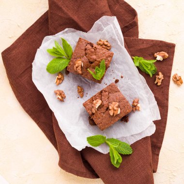 Brownie tatlı çikolata tatlı ceviz ve demek yapraklarla kopya alanı üzerinde pastel bej arka plan - beyaz kağıt üzerinde güzel afiş lezzetli kahverengi Kakaolu pasta pişmiş..