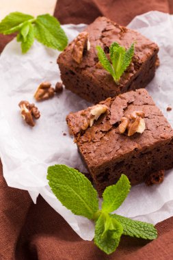 Brownie tatlı çikolata tatlı ceviz ve demek yapraklarla kopya alanı üzerinde pastel bej arka plan - beyaz kağıt üzerinde güzel afiş lezzetli kahverengi Kakaolu pasta pişmiş..