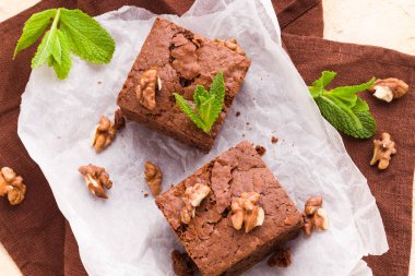 Brownie tatlı çikolata tatlı ceviz ve demek yapraklarla kopya alanı üzerinde pastel bej arka plan - beyaz kağıt üzerinde güzel afiş lezzetli kahverengi Kakaolu pasta pişmiş..