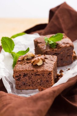 Brownie tatlı çikolata tatlı ceviz ve demek yapraklarla kopya alanı üzerinde pastel bej arka plan - beyaz kağıt üzerinde güzel afiş lezzetli kahverengi Kakaolu pasta pişmiş..