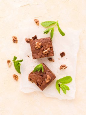 Brownie tatlı çikolata tatlı ceviz ve demek yapraklarla kopya alanı üzerinde pastel bej arka plan - beyaz kağıt üzerinde güzel afiş lezzetli kahverengi Kakaolu pasta pişmiş..