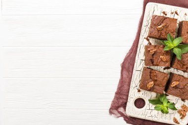 Brownie tatlı çikolata tatlı ceviz ve retro kurulu demek yapraklarda pastel bej renkli arka plan üzerinde kopya alanı ile. Lezzetli kahverengi kakao pişmiş pasta ile güzel afiş.