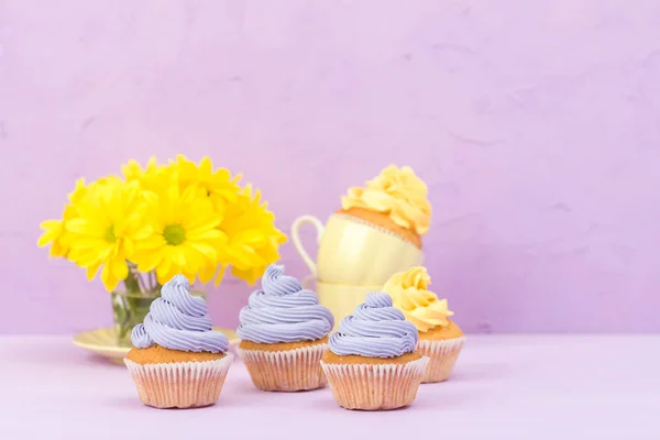 Cupcakes Decorados Con Crema Amarilla Violeta Crisantemos Sobre Fondo Pastel — Foto de Stock