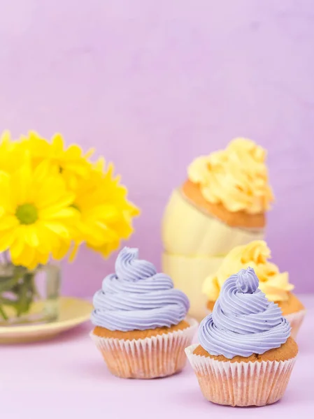 Cupcakes Decorados Con Crema Amarilla Violeta Crisantemos Sobre Fondo Pastel — Foto de Stock