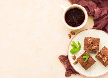 Brownie tatlı çikolata tatlı ceviz ve zanaat plaka ve siyah kahve demek yapraklarda pastel bej arka plan - lezzetli kahverengi pişmiş pasta ile güzel afiş üzerinde kopya alanı ile.