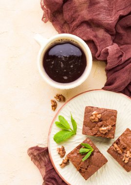 Brownie tatlı çikolata tatlı ceviz ve zanaat plaka ve pastel bej arka plan - lezzetli kahverengi pişmiş pasta ile güzel afiş üzerinde siyah kahve demek yapraklarda.