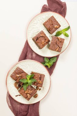 Brownie tatlı çikolata tatlı ceviz ve zanaat plaka üzerinde demek yaprakları ile kopya alanı üzerinde pastel bej arka plan - güzel afiş lezzetli kahverengi Kakaolu pasta pişmiş..