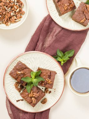 Brownie tatlı çikolata tatlı ceviz ve zanaat plaka ve pastel bej arka plan - lezzetli kahverengi pişmiş pasta ile güzel afiş üzerinde siyah kahve demek yapraklarda.