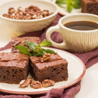 Brownie tatlı çikolata tatlı ceviz ve zanaat plaka ve pastel bej arka plan - lezzetli kahverengi pişmiş pasta ile güzel afiş üzerinde siyah kahve demek yapraklarda.