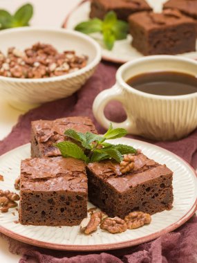 Brownie tatlı çikolata tatlı ceviz ve zanaat plaka ve pastel bej arka plan - lezzetli kahverengi pişmiş pasta ile güzel afiş üzerinde siyah kahve demek yapraklarda.