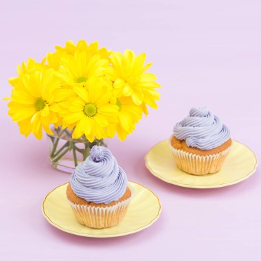 Mor krem ve metin alanı tebrik afiş için Menekşe pastel zemin üzerine sarı Kasımpatı buket cupcakes süslenmiş.