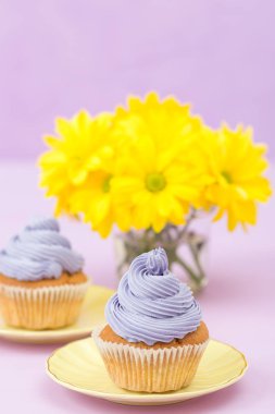 Mor krem ve metin alanı tebrik afiş için Menekşe pastel zemin üzerine sarı Kasımpatı buket cupcakes süslenmiş.