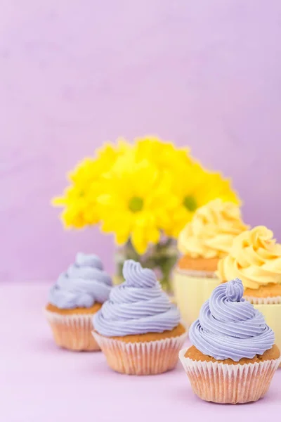 用甜黄色和紫罗兰色奶油和菊花在紫罗兰色的背景上装饰的蛋糕 Copyspace 可用于问候 母亲日和情人节贺卡 简约理念 — 图库照片
