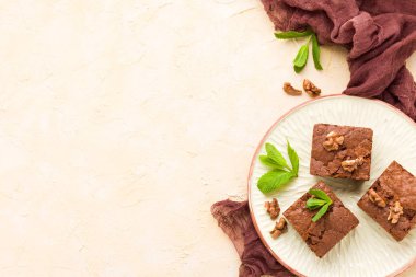 Brownie tatlı çikolata tatlı ceviz ve zanaat plaka üzerinde demek yaprakları ile kopya alanı üzerinde pastel bej arka plan - güzel afiş lezzetli kahverengi Kakaolu pasta pişmiş..