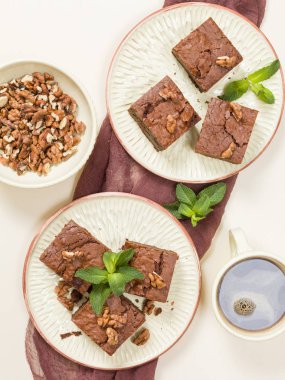Brownie tatlı çikolata tatlı ceviz ve zanaat plaka üzerinde demek yaprakları ile kopya alanı üzerinde pastel bej arka plan - güzel afiş lezzetli kahverengi Kakaolu pasta pişmiş..