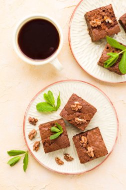 Brownie tatlı çikolata tatlı ceviz ve zanaat plaka ve pastel bej arka plan - lezzetli kahverengi pişmiş pasta ile güzel afiş üzerinde siyah kahve demek yapraklarda.