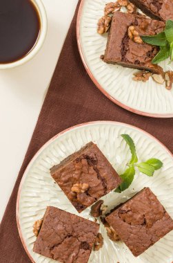 Brownie tatlı çikolata tatlı ceviz ve zanaat plaka ve pastel bej arka plan - lezzetli kahverengi pişmiş pasta ile güzel afiş üzerinde siyah kahve demek yapraklarda.