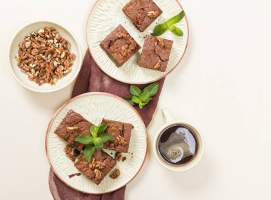 Brownie tatlı çikolata tatlı ceviz ve zanaat plaka üzerinde demek yaprakları ile kopya alanı üzerinde pastel bej arka plan - güzel afiş lezzetli kahverengi Kakaolu pasta pişmiş..