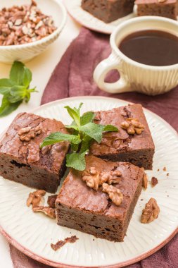 Brownie tatlı çikolata tatlı ceviz ve zanaat plaka ve pastel bej arka plan - lezzetli kahverengi pişmiş pasta ile güzel afiş üzerinde siyah kahve demek yapraklarda.