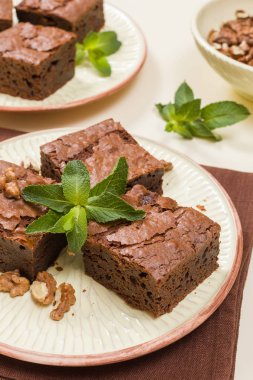 Brownie tatlı çikolata tatlı ceviz ve zanaat plaka üzerinde demek yaprakları ile kopya alanı üzerinde pastel bej arka plan - güzel afiş lezzetli kahverengi Kakaolu pasta pişmiş..
