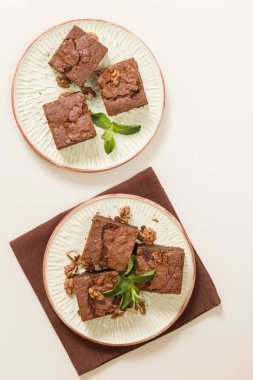 Brownie tatlı çikolata tatlı ceviz ve zanaat plaka üzerinde demek yaprakları ile kopya alanı üzerinde pastel bej arka plan - güzel afiş lezzetli kahverengi Kakaolu pasta pişmiş..