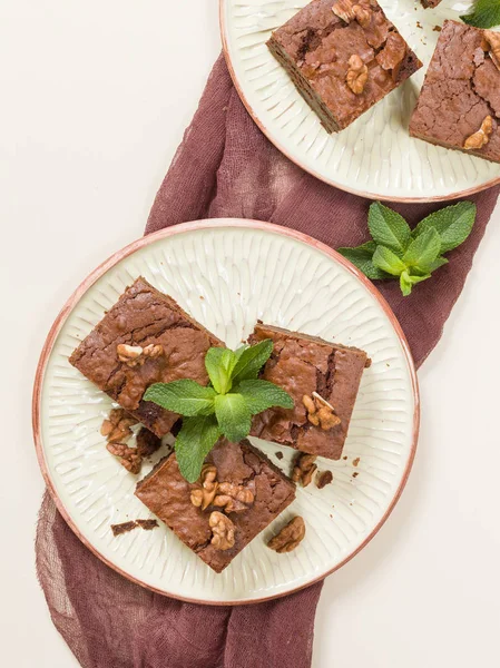 Brownie tatlı çikolata tatlı ceviz ve zanaat plaka üzerinde demek yaprakları ile kopya alanı üzerinde pastel bej arka plan - güzel afiş lezzetli kahverengi Kakaolu pasta pişmiş..