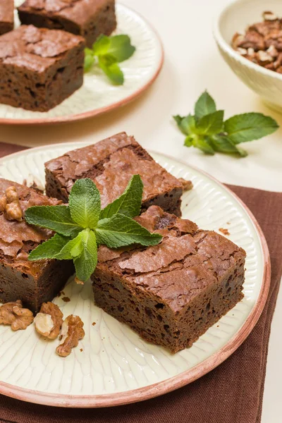 Brownie tatlı çikolata tatlı ceviz ve zanaat plaka üzerinde demek yaprakları ile kopya alanı üzerinde pastel bej arka plan - güzel afiş lezzetli kahverengi Kakaolu pasta pişmiş..