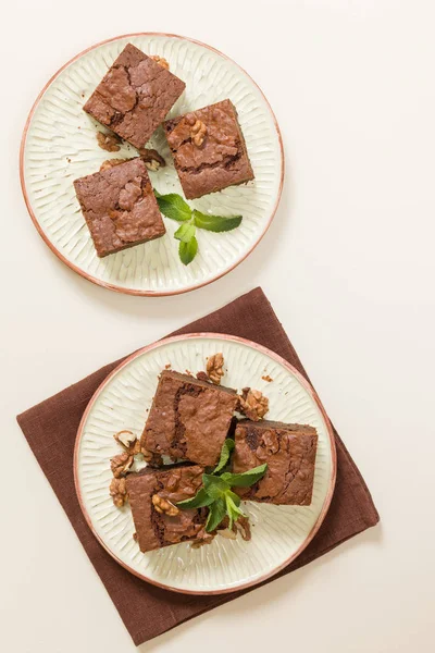Brownie tatlı çikolata tatlı ceviz ve zanaat plaka üzerinde demek yaprakları ile kopya alanı üzerinde pastel bej arka plan - güzel afiş lezzetli kahverengi Kakaolu pasta pişmiş..