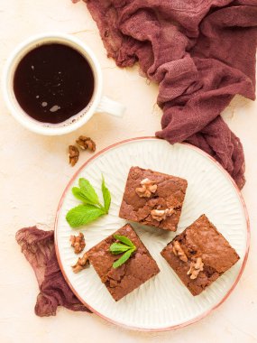 Brownie tatlı çikolata tatlı ceviz ve zanaat plaka ve pastel bej arka plan - lezzetli kahverengi pişmiş pasta ile güzel afiş üzerinde siyah kahve demek yapraklarda.