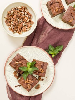 Brownie tatlı çikolata tatlı ceviz ve zanaat plaka üzerinde demek yaprakları ile kopya alanı üzerinde pastel bej arka plan - güzel afiş lezzetli kahverengi Kakaolu pasta pişmiş..