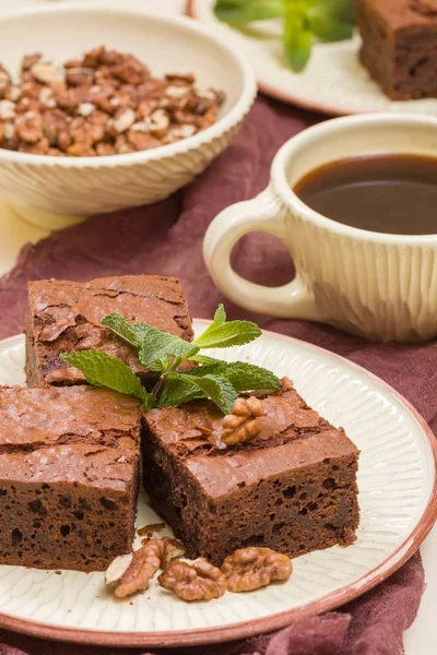 Brownie tatlı çikolata tatlı ceviz ve zanaat plaka ve pastel bej arka plan - lezzetli kahverengi pişmiş pasta ile güzel afiş üzerinde siyah kahve demek yapraklarda.