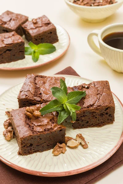 Brownie tatlı çikolata tatlı ceviz ve zanaat plaka ve pastel bej arka plan - lezzetli kahverengi pişmiş pasta ile güzel afiş üzerinde siyah kahve demek yapraklarda.