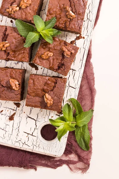 Brownie tatlı çikolata tatlı ceviz ve retro kurulu demek yapraklarda pastel bej renkli arka plan üzerinde kopya alanı ile. Lezzetli kahverengi kakao pişmiş pasta ile güzel afiş.