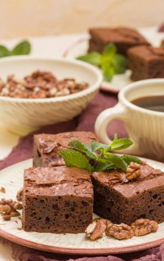 Brownie tatlı çikolata tatlı ceviz ve zanaat plaka ve pastel bej arka plan - lezzetli kahverengi pişmiş pasta ile güzel afiş üzerinde siyah kahve demek yapraklarda.