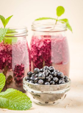 Olgun vahşi orman meyveleri ve yeşil nane yaprakları ile ham blueberry smoothie.