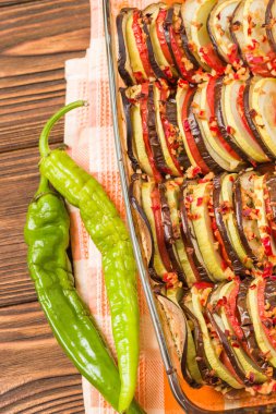 Ratatouille yakın taze pişmiş vejetaryen yemek ve yeşil biber kahverengi ahşap arka plan - config byaldi vegan gıda ve beslenme kavramı için en iyi görünümü ile dikey fotoğraf çekim.