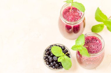 Blueberry smoothie yakın fotoğraf yaz karışımlı vitamin kokteyl ile kadar taze yeşil nane yaprakları ve kopya alanı sarı pastel zemin üzerine Ham Olgun meyveleri süslenmiş.