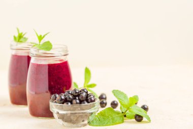 Taze yeşil nane yaprakları ve ham Olgun meyveleri yaz karışımlı vitamini sağlıklı gıda kavramı için kokteyl şeffaf kavanoz sarı pastel arka planda - frenk üzümü güler yüzlü süslenmiş.