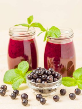 Taze yeşil nane yaprakları ve ham Olgun meyveleri yaz karışımlı vitamini sağlıklı gıda kavramı için kokteyl şeffaf kavanoz sarı pastel arka planda - frenk üzümü güler yüzlü süslenmiş.