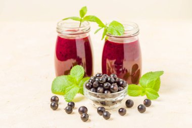 Taze yeşil nane yaprakları ve ham Olgun meyveleri yaz karışımlı vitamini sağlıklı gıda kavramı için kokteyl şeffaf kavanoz sarı pastel arka planda - frenk üzümü güler yüzlü süslenmiş.