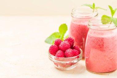 Ahududu güler yüzlü yakın taze yaz fotoğrafla kadar kokteyl ve olgun çilek sağlıklı beslenme ve yaşam tarzı konsepti için pastel sarı zemin üzerine karışık.