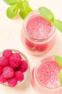 Ahududu güler yüzlü yakın taze yaz fotoğrafla kadar kokteyl ve olgun çilek sağlıklı beslenme ve yaşam tarzı konsepti için pastel sarı zemin üzerine karışık.