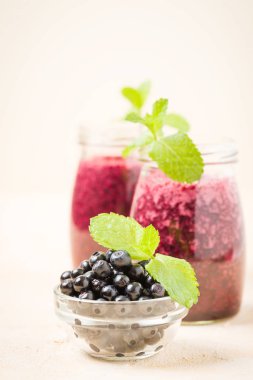 Blueberry smoothie yakın fotoğraf yaz karışımlı vitamin kokteyl ile kadar yeşil nane yaprakları ve sağlıklı gıda kavramı için sarı pastel arka plan üzerinde ham Olgun meyveleri süslenmiş.