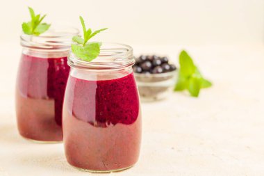 Taze yeşil nane yaprakları ve ham Olgun meyveleri yaz karışımlı vitamini sağlıklı gıda kavramı için kokteyl şeffaf kavanoz sarı pastel arka planda - frenk üzümü güler yüzlü süslenmiş.