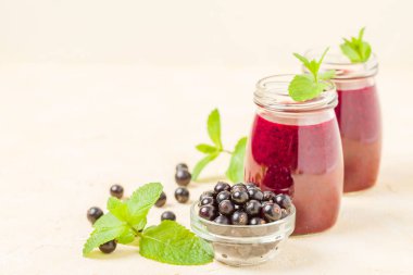 Taze yeşil nane yaprakları ve ham Olgun meyveleri yaz karışımlı vitamini sağlıklı gıda kavramı için kokteyl şeffaf kavanoz sarı pastel arka planda - frenk üzümü güler yüzlü süslenmiş.