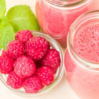 Ahududu güler yüzlü yakın taze yaz fotoğrafla kadar kokteyl ve olgun çilek sağlıklı beslenme ve yaşam tarzı konsepti için pastel sarı zemin üzerine karışık.